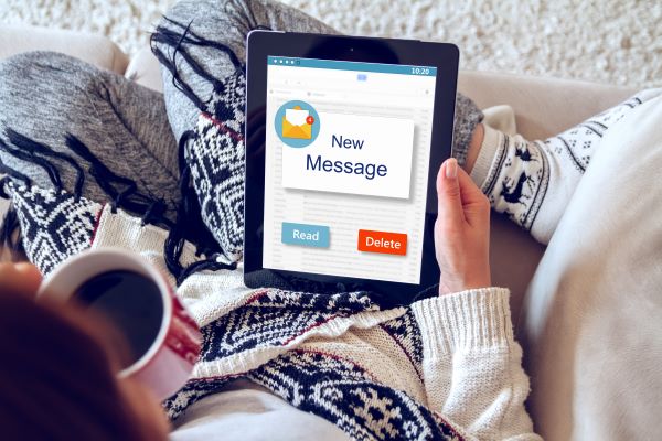 A photo of a woman holding a tablet on which she has received a new message