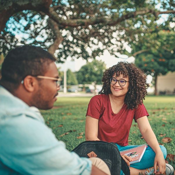 A group of smiling students at a park.