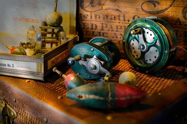 Fishing reel, lures, and other essentials in a tacklebox.